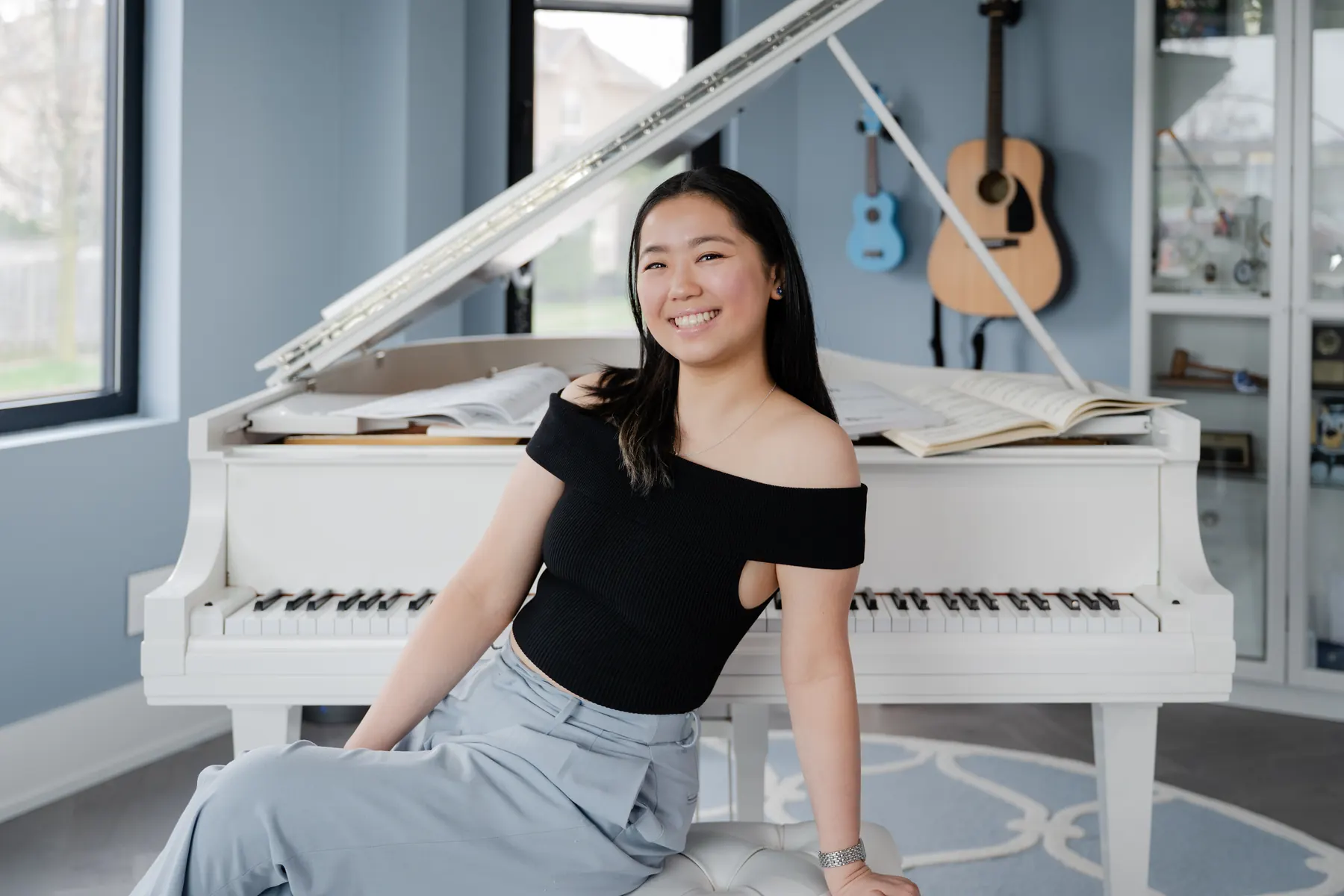 Erin Yip beside a white piano